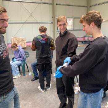Zwei Auszubildene messen gegenseitig ihren Puls bei einem betrieblichen Seminar über Arbeitssicherheit